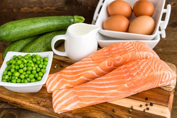 Raw salmon filet with vegetables on wooden cutting board. Ingredients for clafoutis — Stock Photo, Image