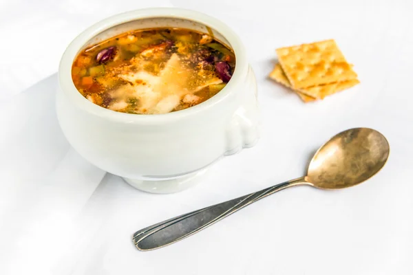 Tigela de sopa de minestrone com parmesão fatiado no fundo branco — Fotografia de Stock