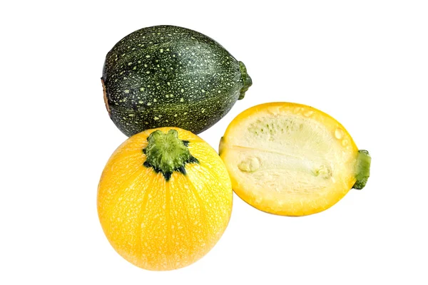 Raw round yellow and green zucchini and a cut one isolated on white. Stock Photo