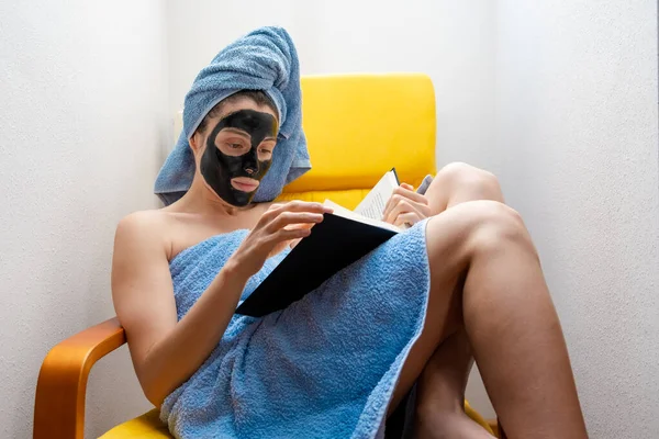 Mujer Joven Leyendo Libro Mientras Relaja Sofá Con Una Máscara — Foto de Stock