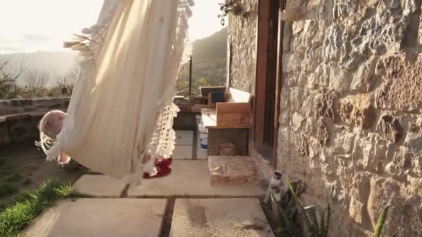 Blond Klein Meisje Swingen Speels Een Hangmat Tijdens Zonsondergang — Stockvideo