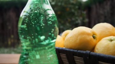 Limonlu hasır sepetin yanındaki köpüklü su şişesini kapat..