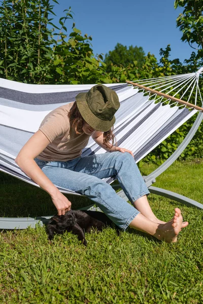 Jovem Espanhola Sentada Rede Acariciando Gato Preto Jardim Ela Está — Fotografia de Stock