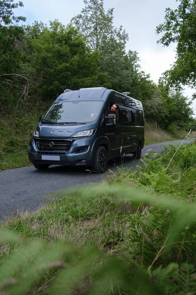 Man driving a camper van in the wilderness. Vertical photo.
