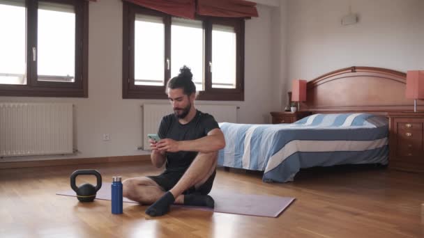 Vousatý Muž Pomocí Svého Mobilního Telefonu Zatímco Odpočívá Podlaze Jeho — Stock video