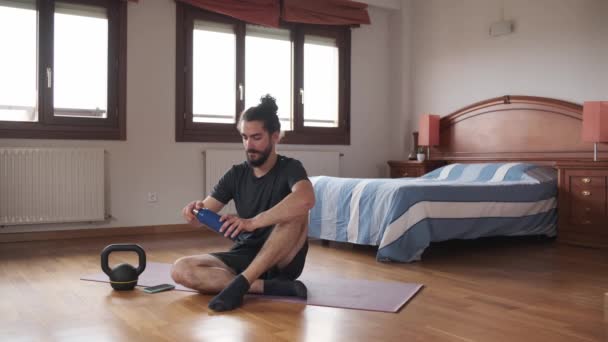 Vousatý Muž Pije Vodu Zatímco Odpočívá Podlaze Jeho Domácí Cvičení — Stock video