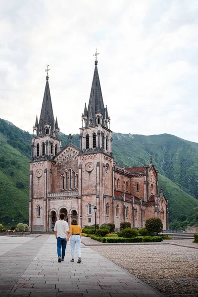 İspanya 'nın Asturias kentindeki Covadonga Sığınağı' na doğru yürüyen çift. Dikey fotoğraf.