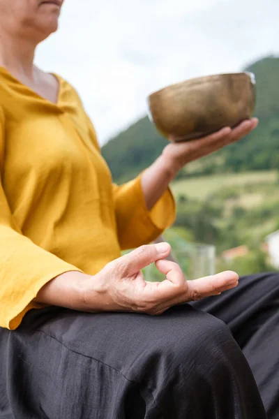 Tanımlanamayan bir kadın elleriyle Mudra işareti yaparken meditasyon yapıyor..