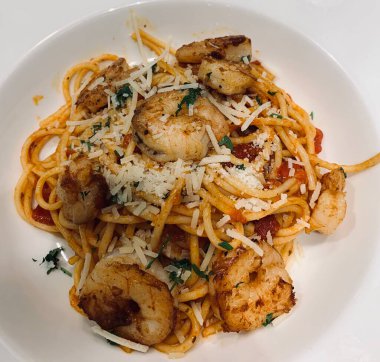 Beyaz tabakta karides ve peynirli makarna.