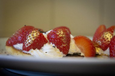 Altın püskürtülmüş çilekleri ve kremayı çikolata parçacıklarıyla kapayın.