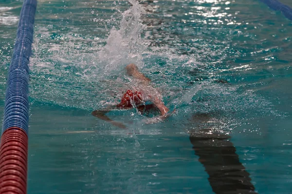 Swimmer in the pool. Freestyle swimming. Low key, dark background, spot lighting, and rich Old Masters — Stock Photo, Image