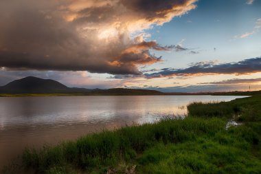 Gölde. yağmurdan sonra muhteşem gün batımı. Düşük anahtar, koyu arka plan, spot aydınlatma ve zengin eski ustalar