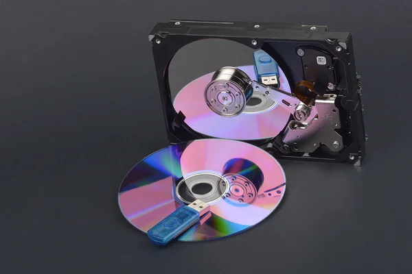 Tarjeta flash que se encuentra en un disco y un disco duro abierto sobre fondo gris oscuro — Foto de Stock
