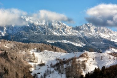 Arka planda Bucegi Dağları ile vahşi Transilvanya tepelerde bir kışın güneşli gün.