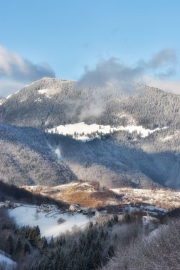 Arka planda Bucegi Dağları ile vahşi Transilvanya tepelerde bir kışın güneşli gün.
