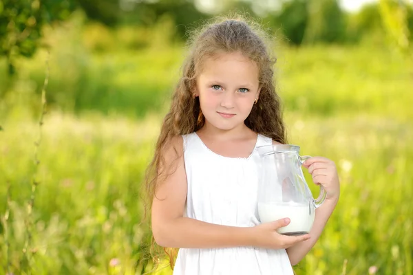 Primer plano retrato niña sosteniendo jarra de leche al aire libre verano — Foto de Stock