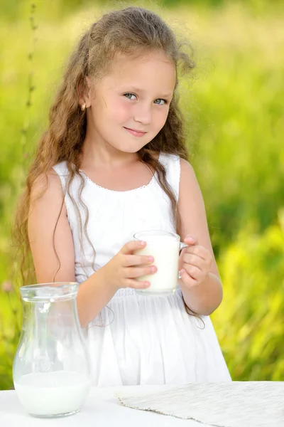 Primer plano retrato niña sosteniendo vaso de leche al aire libre verano — Foto de Stock