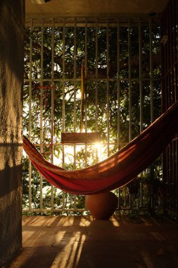 Hamak, güvenli verandada altın saatinde arka planda.