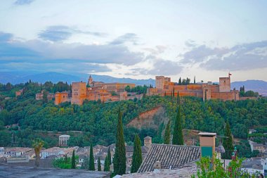 Şafak vakti Alhambra sarayı ve kalesi, Granada, İspanya. Eski Arap kalesi ve ufukta Sierra Nevada dağları olan şehir manzarası.