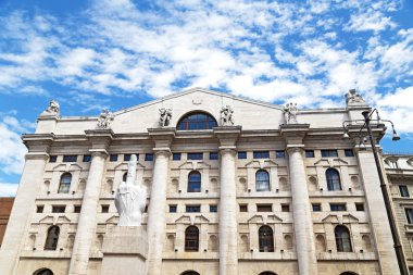 MILAN, ITALY - JULY 9, 2014: Maurizio Cattelan sculpture of pointed middle finger in front of stock exchange building in Milan on July 9, 2014.