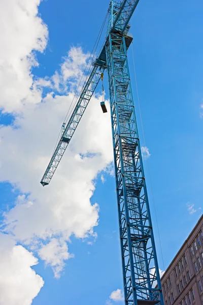 Blå konstruktion kran mot en molnig himmel. — Stockfoto