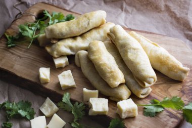 Fırın taze fırın içi doldurulmuş ekmek ve peynir. Tahta kesme tahtasında lezzetli hamur işleri .