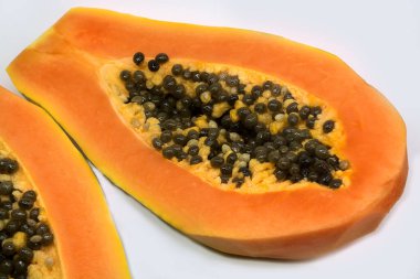  olgunlaşmış papaya meyvesi ikiye bölünmüş tohumlar beyaz arka planda izole edilmiş. 