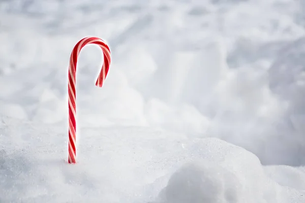 Bastone di menta piperita caramella di Natale con sfondo nevicata. Spazio per testo — Foto Stock