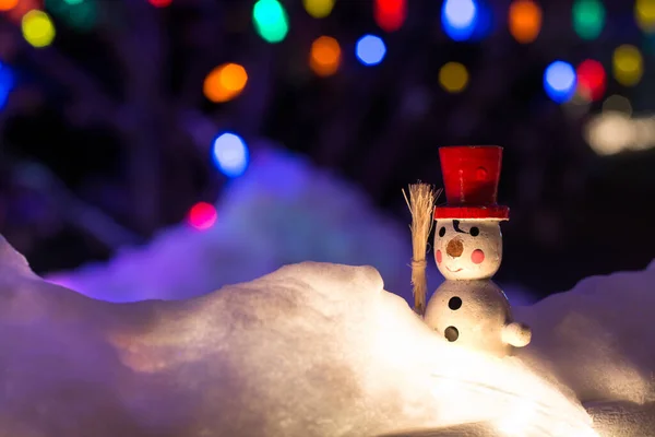 Pupazzo di neve vintage nella neve su sfondo notturno con luci di Natale — Foto Stock