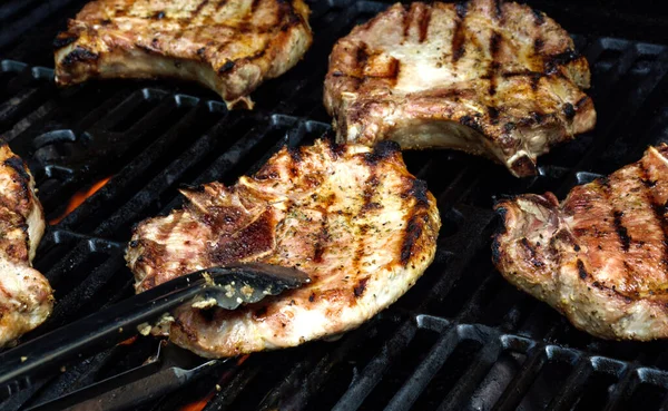 Délicieuse viande grillée sur barbecue grill avec de la fumée et des flammes. Griller le porc à l'extérieur. — Photo