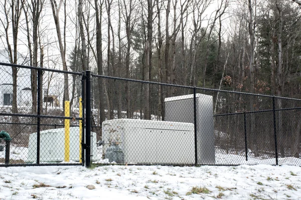 Emergency generator for uninterruptible power supply behind metal fence — Stock Photo, Image