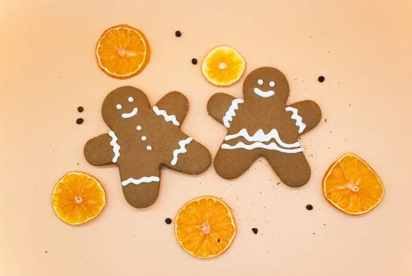 Biscoitos de gengibre caseiros de Natal com fatias de laranjas no fundo laranja claro — Fotografia de Stock