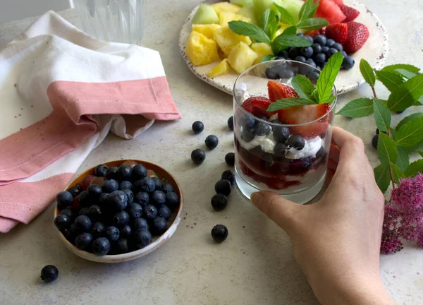 Gyümölcssaláta és természetes görög joghurt friss bogyókkal. Kézi pohár joghurttal és gyümölccsel — Stock Fotó