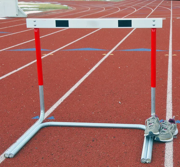 Trackshoes and hurdle — Stock Photo, Image