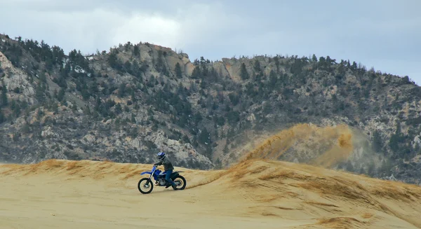 Trickfahrer, Dirtbike-Motocross-Fahrer sprühen Sand — Stockfoto