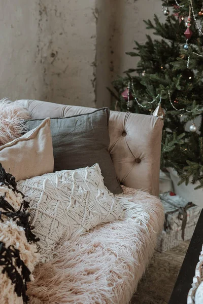 Cozy boho style living room. many pillows on sofa. christmas tree indoor. Slow living concept.