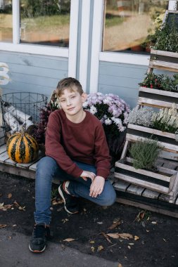 boy with flowers and pumpkins in the park