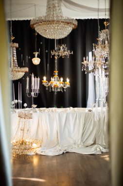 Avizeler ve perdelerle süslenmiş zarif bir oda.