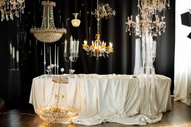 Zarif dekore edilmiş bir masa ve asılı avizeler.