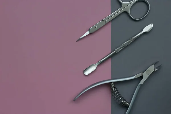 manicure tools, Cuticle nipper, Nail scissors, Cuticle pusher. Iron and sharp manicure tools. Top view, close-up