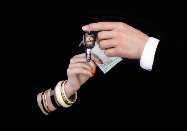 Pánská ruka ženská ruka eurobanknotes a klíče od auta — Stock fotografie