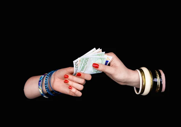 Kvinnans hand att ge till andra kvinnans hand eurosedlar — Stockfoto