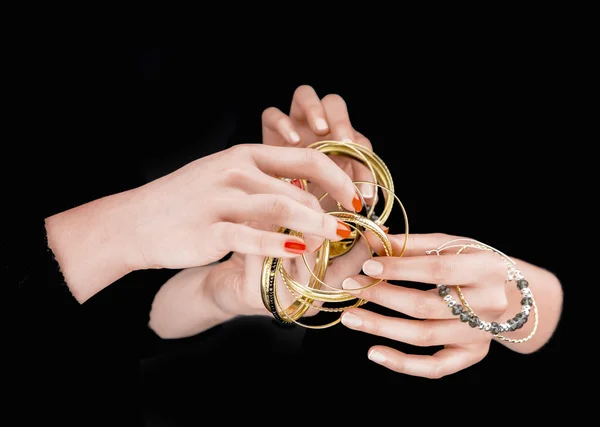Two women's hands with golden bracelets — Stock Photo, Image