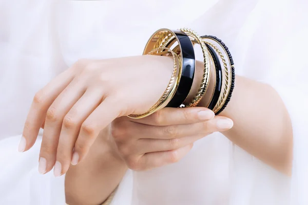 Girl's handen met gouden armbanden — Stockfoto