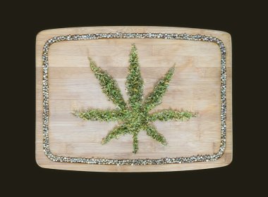 Cannabis symbol made of dried hemp leaves on a wooden bamboo boa clipart