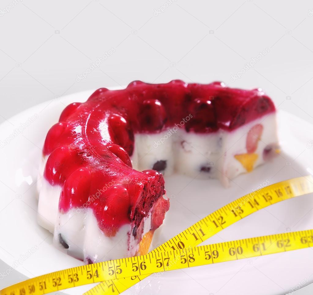 Piece of a fruit jelly cake with a measuring tape 