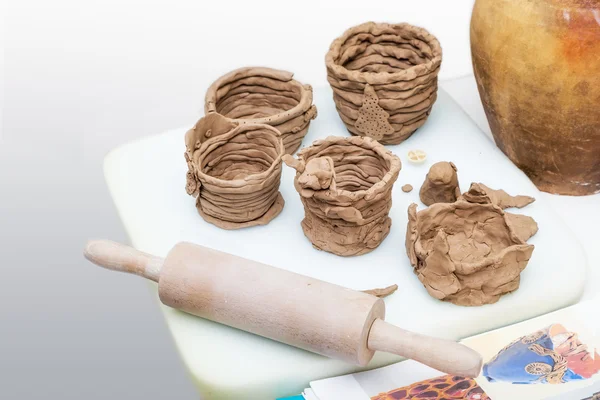 Many amateur handmade unbaked clay moldings and rolling-pin — Stock Photo, Image