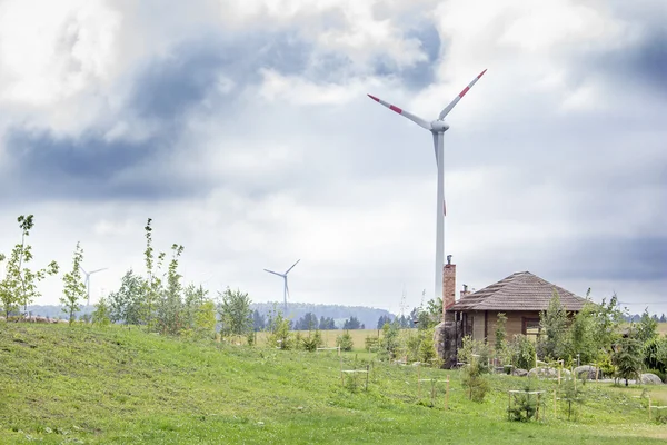 Turbinas eólicas en un campo con un granero y un jardín cerca — Foto de Stock