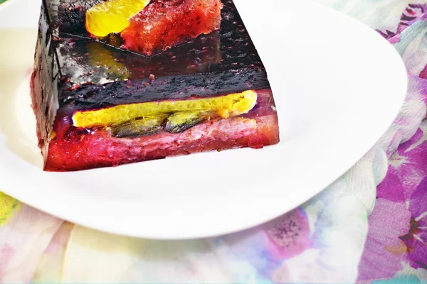 Gâteau à la gelée colorée avec une variété de fruits dans une assiette — Photo