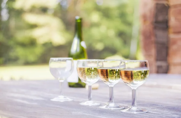 Quattro bicchieri da vino e una bottiglia di vino — Foto Stock